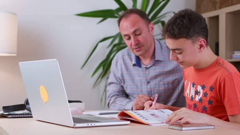 male tutor helping middle school student math at home